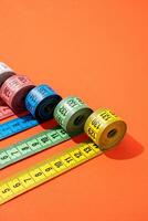 colorful measuring tapes top view on bright red background photo