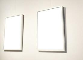 Blank picture frames on grey wall with glowing lamp, mock up photo