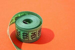 colorful measuring tapes top view on bright red background photo