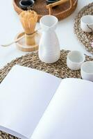 Book mockup design. Blank white book on dining table in asian style with tableware photo