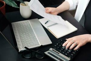 exitoso financiero planificación. mujer de negocios en contabilidad. de cerca de contador a trabajar. documento y calculadora en mano. eficiente presupuesto evaluación. mujer de negocios en Finanzas papel foto