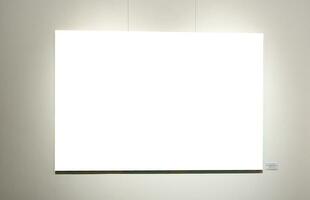 Blank picture frames on grey wall with glowing lamp, mock up photo