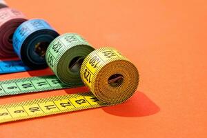 colorful measuring tapes top view on bright red background photo