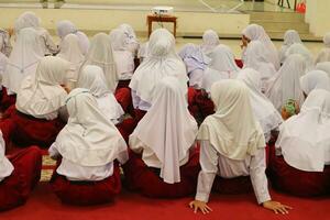 Elementary school boys and girls sitting watching the teacher photo