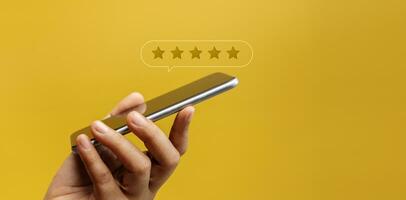 Customer Experiences Concept. Happy Client Using Smartphone to Submit Five Star Review Rating for Online Satisfaction Surveys. Positive Feedback on Mobile Phone photo