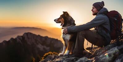 excursionismo con el perro, un joven hombre y su activo frontera collie perro sentado en acantilado rock a tomar un ver de amanecer después largo sendero trekking en el montaña picos ocupaciones con mascota. ai generativo foto