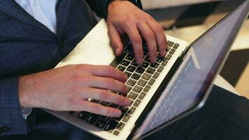 Hands write text messages on a laptop keyboard close-up. Busy businessman emailing a client using a digital wireless handheld device remotely. Software, online education, apps, concept video