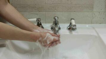 Woman washes hands with water close-up in the sink. Skin hygiene and protection from coronavirus, wash his fingers, stop the spread of bacteria, splashes and drops video