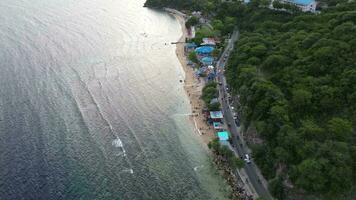 Aerial view of People bathing in the sun, swimming, and playing games on the beach. Top view from drone at beach and azure sea video