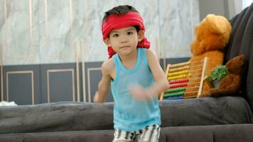 asiatisk pojke i tank topp håller på med övning och där var en svettas handduk på hans huvud. video