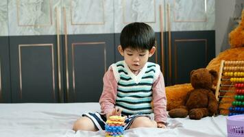 Asian boy playing with jigsaw puzzles on the bed joyfully video