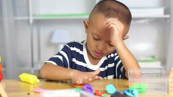 Boy making plasticine to promote development on the table in the house. video