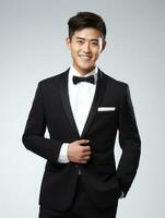 Smiling young man of Asian descent dressed in suit on gray background AI Generative photo