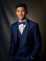 sonriente joven hombre de asiático descendencia vestido en traje en gris antecedentes ai generativo foto