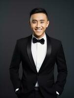 Smiling young man of Asian descent dressed in suit on gray background AI Generative photo