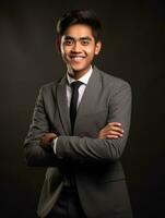 Smiling young man of Asian descent dressed in suit on gray background AI Generative photo