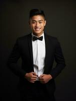 Smiling young man of Asian descent dressed in suit on gray background AI Generative photo