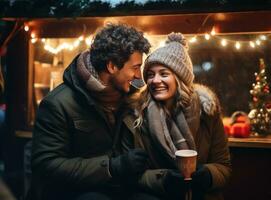 young couple drinking hot cocoa at market with ornaments photo