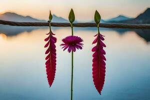 three pink flowers on a wire with a lake in the background. AI-Generated photo