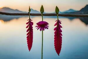 three pink flowers on a wire with a lake in the background. AI-Generated photo