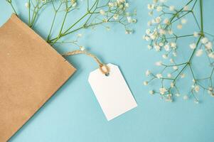 A mock-up of a tag, label and price tag near a craft bag with flowers lie on a colorful yellow table photo