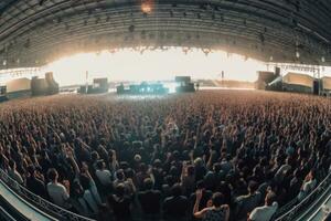 un panorámico Disparo de un grande concierto etapa con el banda jugando a un masivo audiencia. generativo ai foto