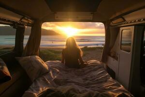 Van on the beach in Hawaii. A young woman sitting inside of it watching the sunset peacefully. Generative Ai photo