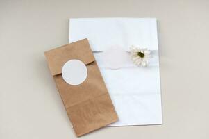 Bosquejo de un redondo pegatina en un regalo blanco y Kraft paquete, un sobre con un vacío pegatina foto