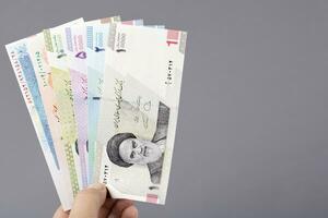 Iranian money in the hand on a gray background photo