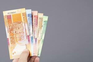 South African money in the hand on a gray background photo