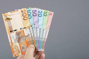 Gambian money in the hand on a gray background photo