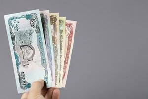 Afghan money in the hand on a gray background photo