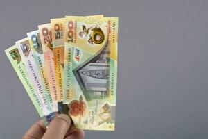 Papua New Guinean money in the hand on a gray background photo