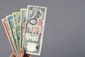 Nepalese money in the hand on a gray background photo