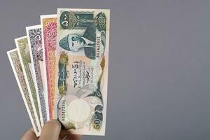 Old Pakistani money in the hand on a gray background photo