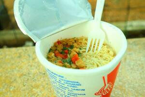 Eat Instant Noodles with Plastic Fork, complete with vegetables photo