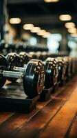 Neatly organized rows of dumbbells await gym goers for diverse weightlifting exercises Vertical Mobile Wallpaper AI Generated photo