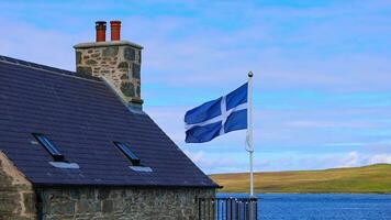 Shetland bandera ondulación en un típico medieval casa en lerwick céntrico y Puerto en Escocia, Inglaterra foto