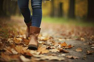 Woman in jeans and boots walking on autumn park. Closeup of the feet. Autumn fashion concept, autumn trend. Generative AI photo