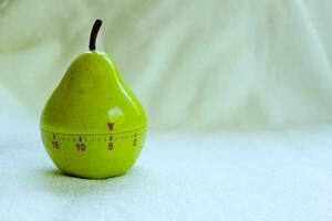 Kitchen egg timer in pear shape turned on 5 minutes isolated photo