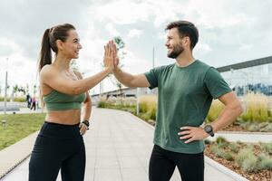 personas en ropa de deporte juntos, físico educación y Deportes. atlético hombre y mujer tren en aptitud y correr. utilizando inteligente relojes y un aptitud aplicación equipo ejercicios de un joven Pareja. foto