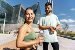 utilizar un aptitud reloj y un aplicación masculino y hembra Atletas tren en aptitud y correr. equipo ejercicios de un joven Pareja. personas en ropa de deporte juntos, físico educación y Deportes. foto