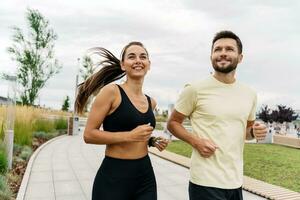 Runners are a young couple training on the street. Athletes are friends of running exercises. A fitness instructor and a woman training in sportswear and sneakers. photo