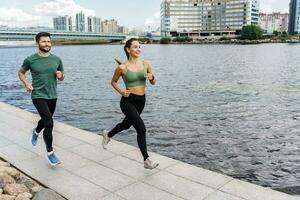 Running in the fresh air. A woman and a man doing sports running. Friends run together. Fitness exercises for a healthy lifestyle. Sports people, training together. photo