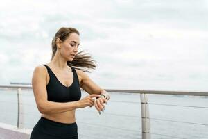 Coach running athlete woman train in the fresh air. Runners are getting ready for a run. Fitness exercises for a healthy lifestyle. Use a fitness watch and  sports. photo