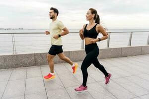 un hombre y un mujer formación juntos. amigos al aire libre ejercicio físico actividad para el cuerpo. personas en aptitud ropa y zapatillas son haciendo Deportes. utilizar un aptitud mirar. foto