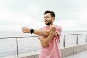 Male runner training fitness in comfortable sportswear. The trainer does a running exercise every day, a healthy lifestyle. A sporty person Uses a fitness watch. photo
