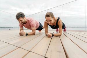 Instructors are a woman and a man in fitness running clothes. People workout trainers use fitness watch and app for exercise results. Physical education together, family couple healthy lifestyle. photo