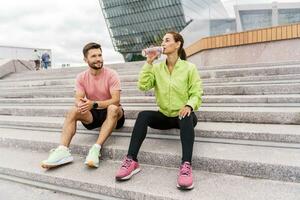 Using smart watches and a fitness app.  Male and female athletes train in fitness and running.  Team exercises of a young couple. People in sportswear together, physical education and sports. photo