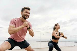 Fitness friends exercises for a healthy lifestyle. Sports people, training together. A woman and a man doing running sports are getting ready to run. Use a fitness watch and a bracelet photo